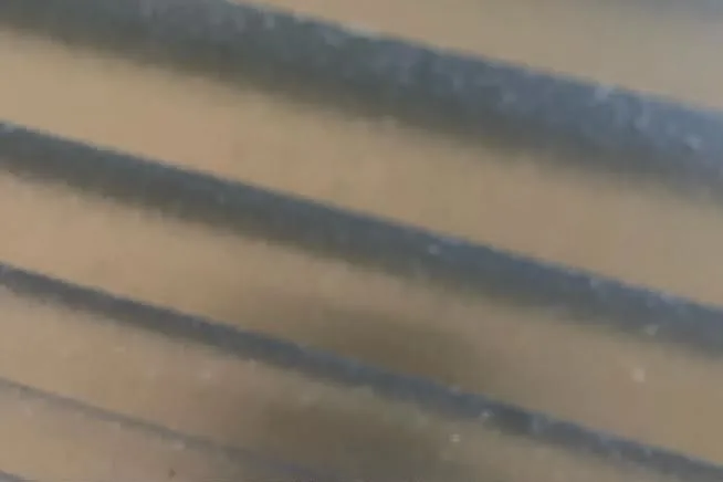 Venetian blind slats before cleaning with visible dust and greasy residue